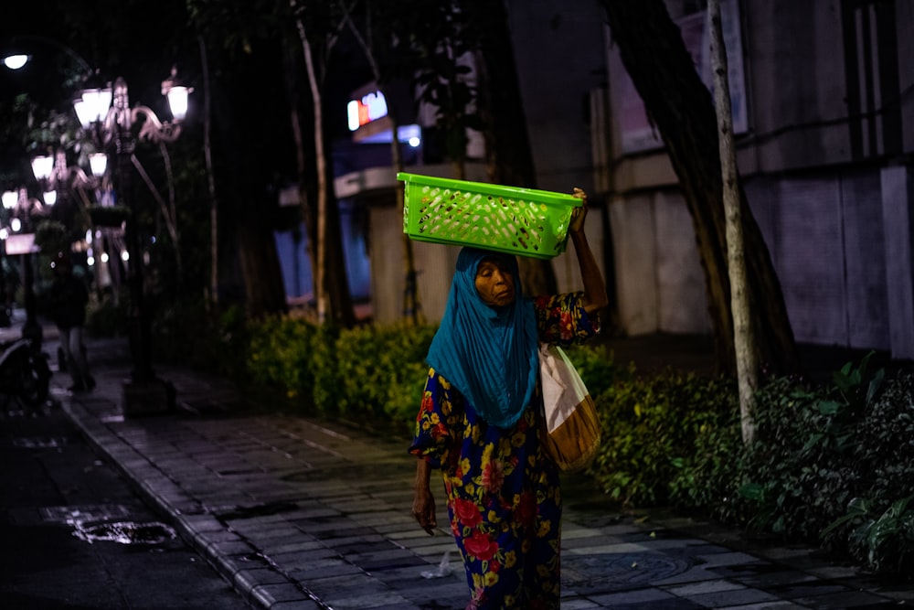 woman carrying green plastic basket
