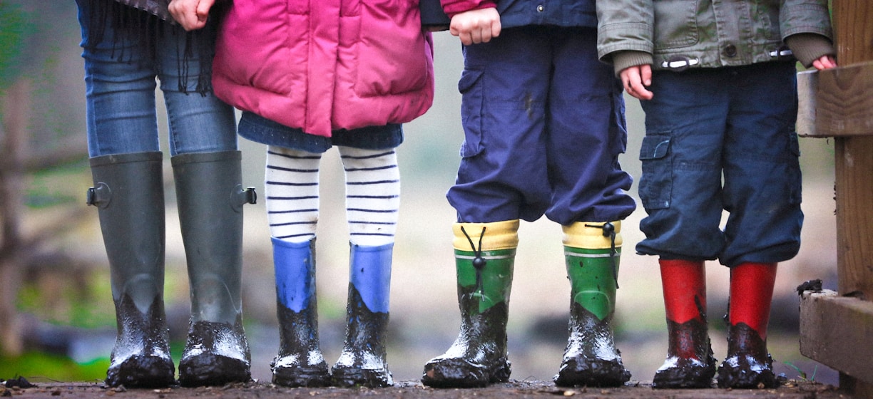 four children standing on dirt during daytime