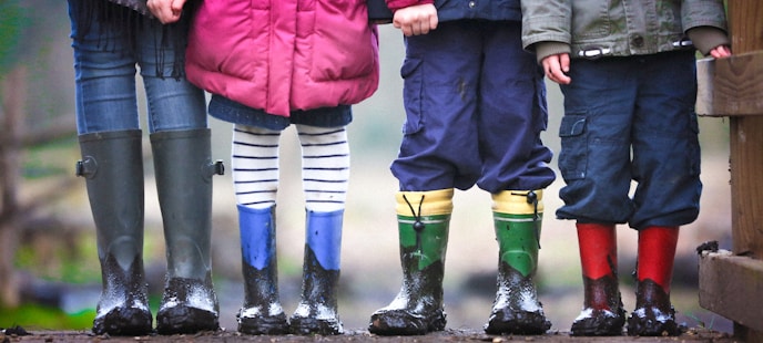 four children standing on dirt during daytime