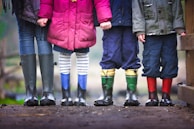 four children standing on dirt during daytime