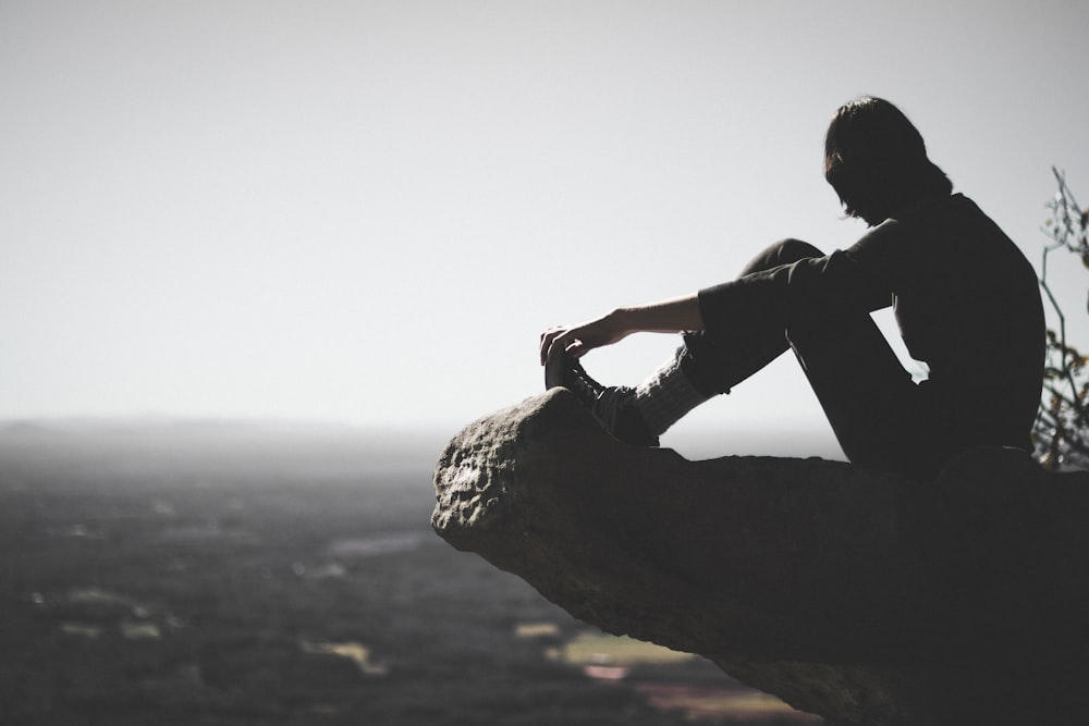 person sitting on cliff