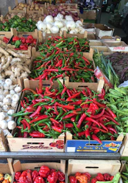 A vibrant display of fresh exotic vegetables arranged in rustic wooden crates at a bustling market.