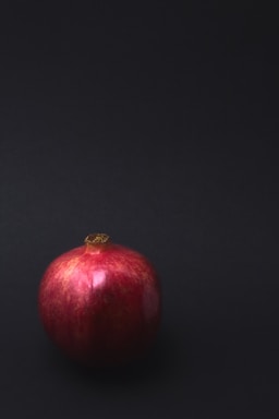 negative space for photo composition,how to photograph still life, pomegranate; round red fruit