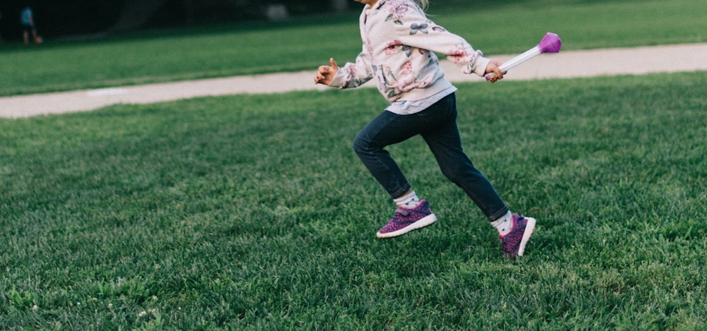 Menina correndo no campo verde