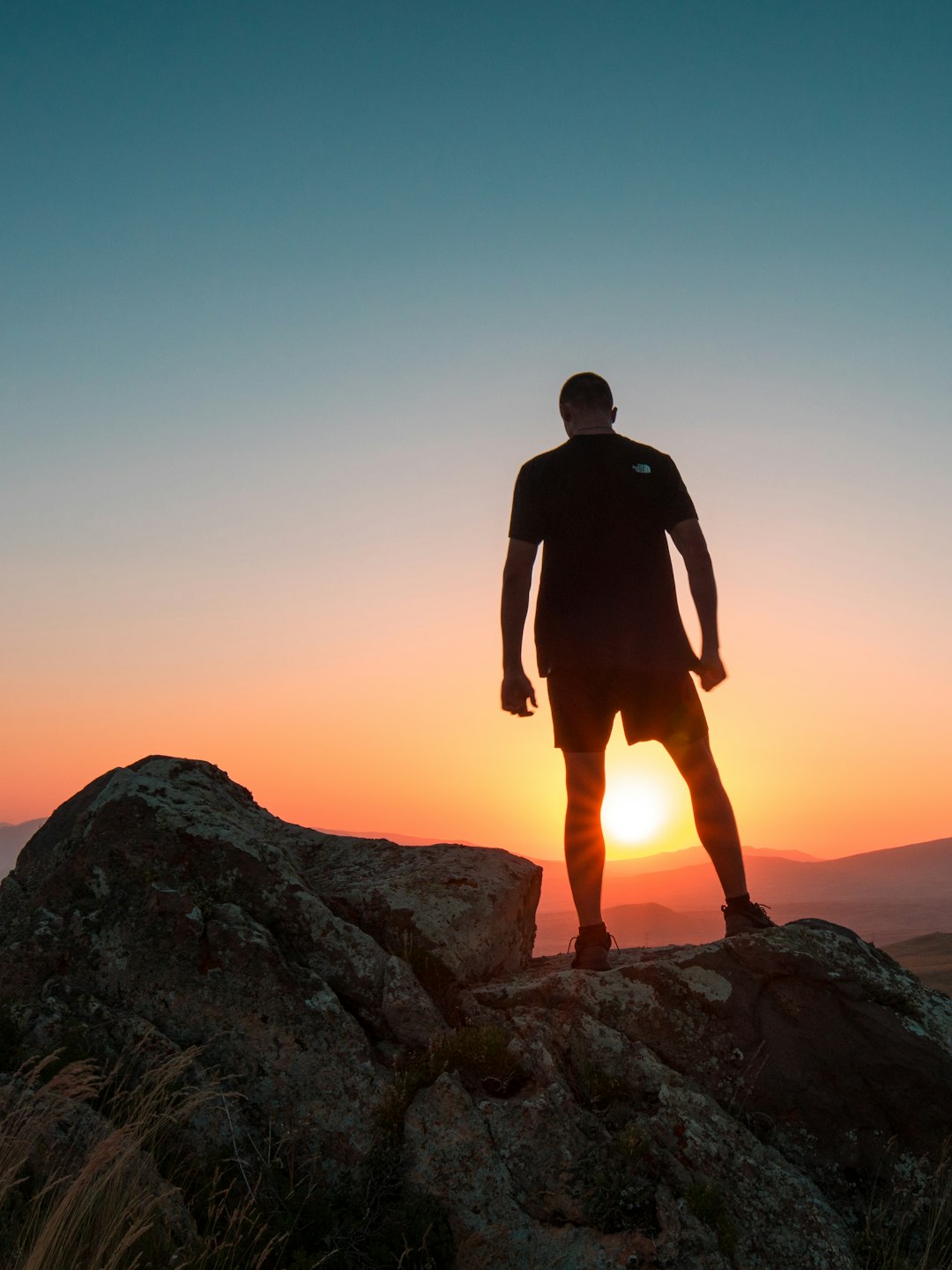 man standing on boulder