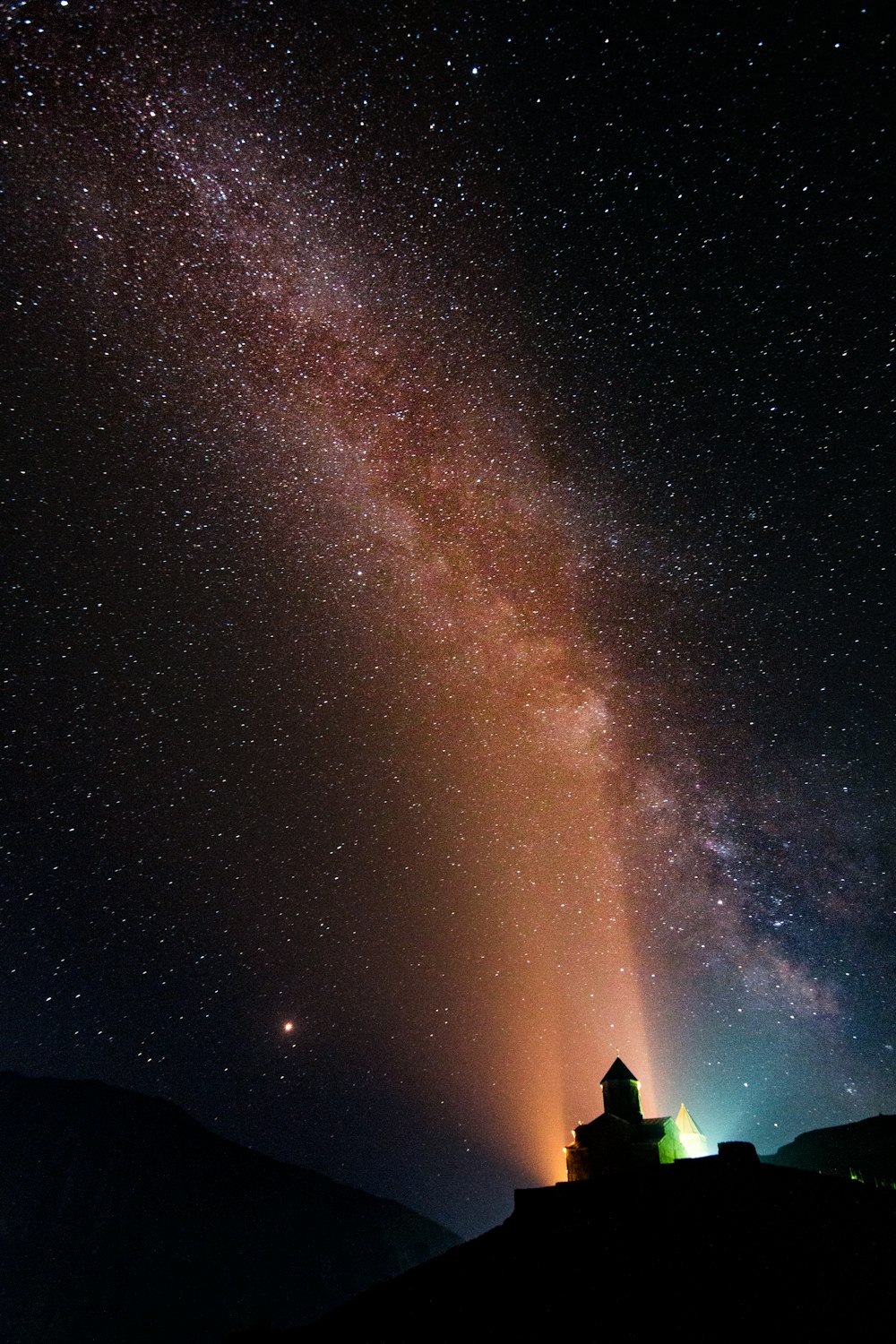 silhouette of house under galaxy