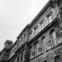 Black-and-white photo of a historic building facade with deep brick red accents.