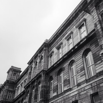 Black-and-white photo of a historic building facade with deep brick red accents.