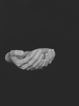 Close-up of hands giving and receiving a donation envelope.