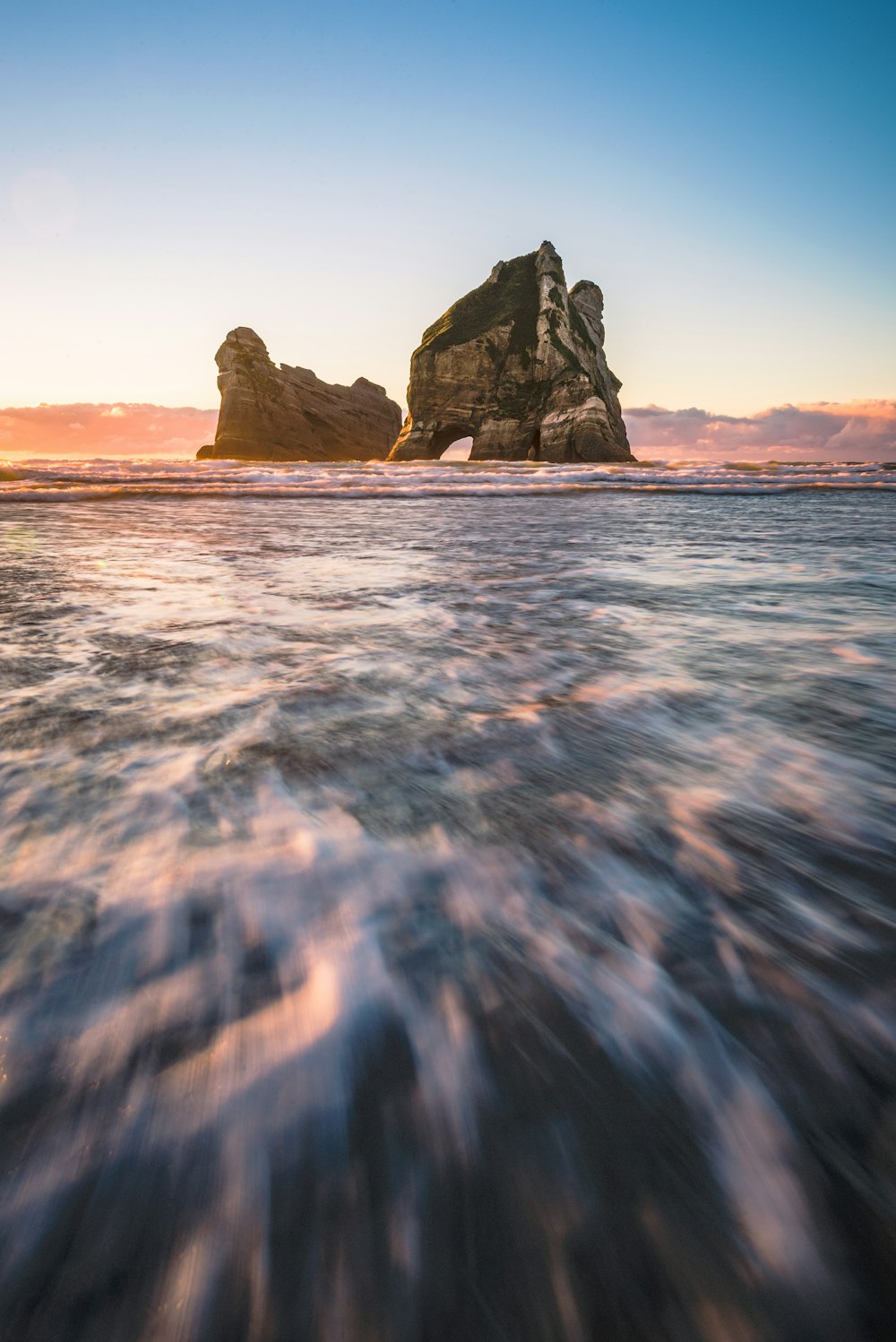 rock formation on body of water during daytime