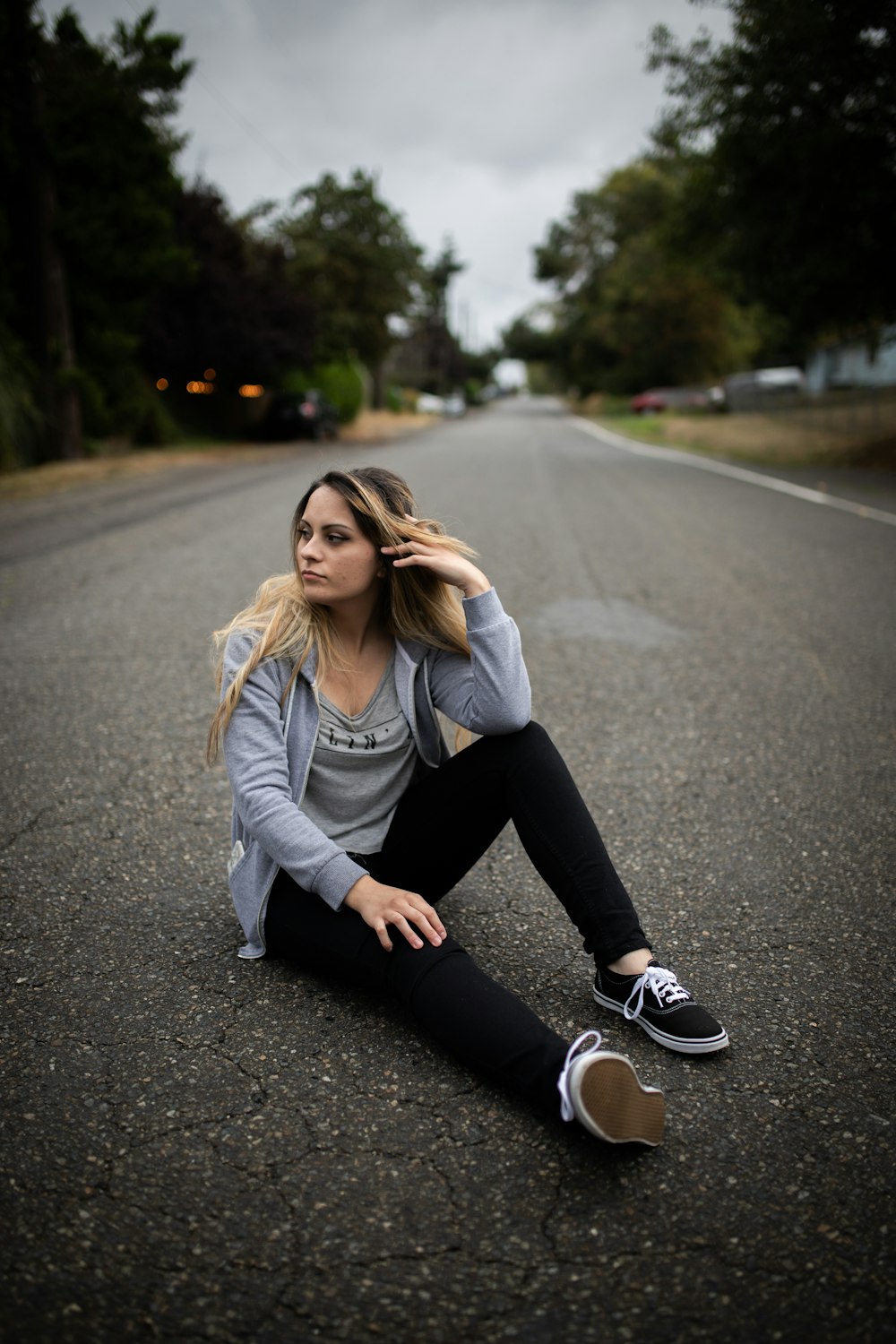 donna che si siede sulla strada vuota