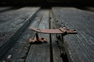 A close-up of various metal hinges arranged on a wooden surface.