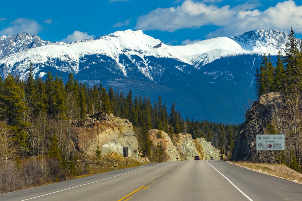 estrada aberta perto da montanha e árvores durante o dia