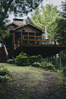 Standard cabin surrounded by tall trees with a wooden deck perfect for relaxing.