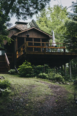 Cozy riverside chalet with wooden deck overlooking lush rainforest.