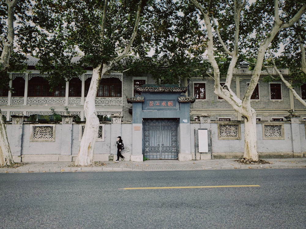 woman walking beside house gate