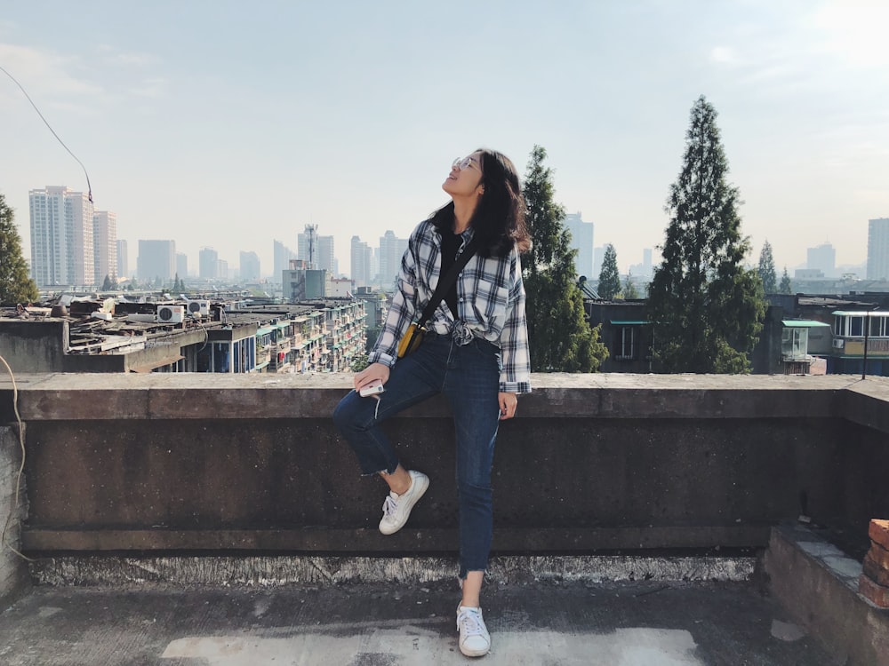 woman sitting on ledge during daytime