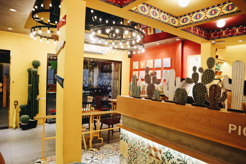A warmly lit interior shot of Saboresía, showcasing rustic wooden tables and vibrant Mexican decor.