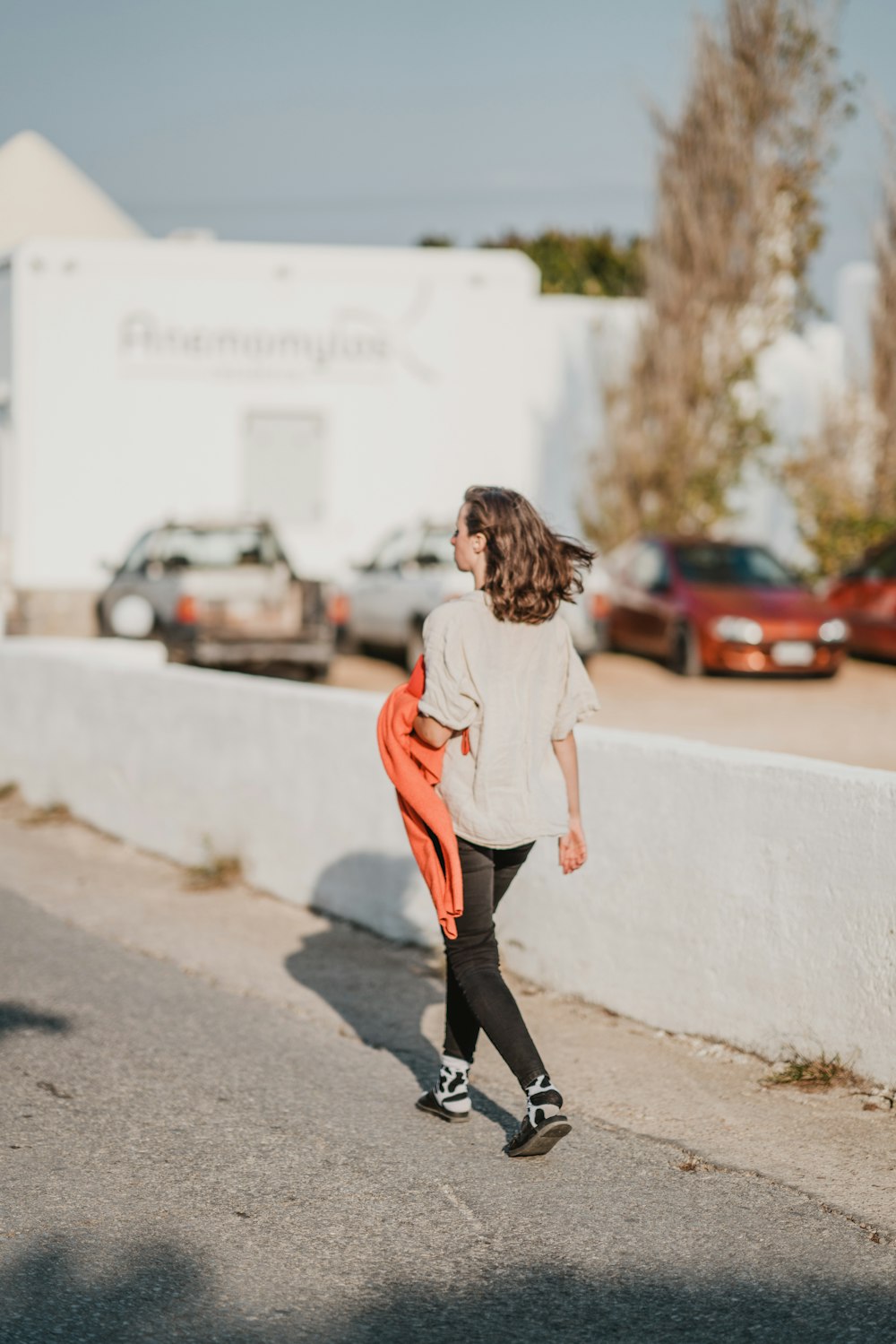 woman wearing white shirt walking on road