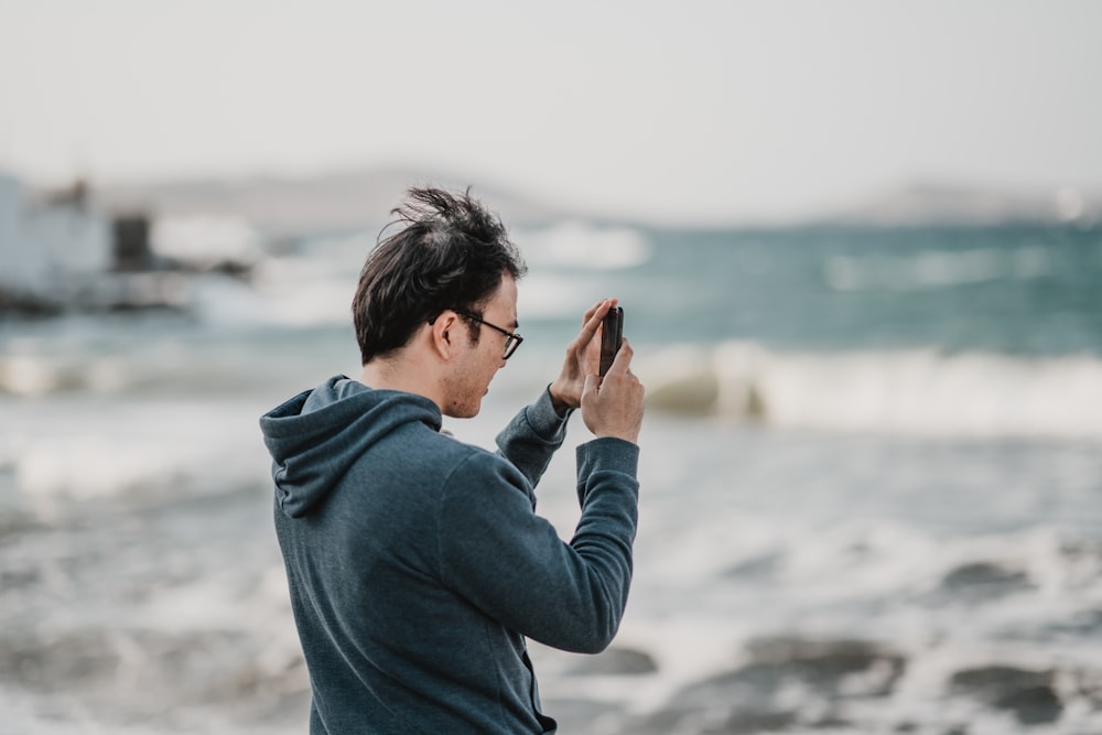 man taking photo of sea