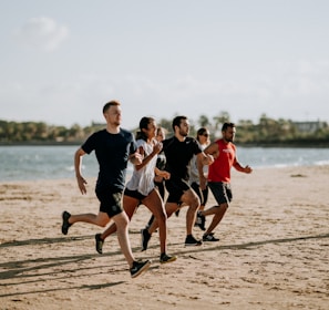 men and women running on sea shore