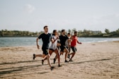 men and women running on sea shore