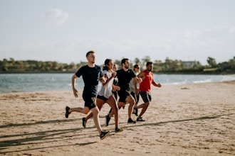 Löpargrupp springer tillsammans på stranden