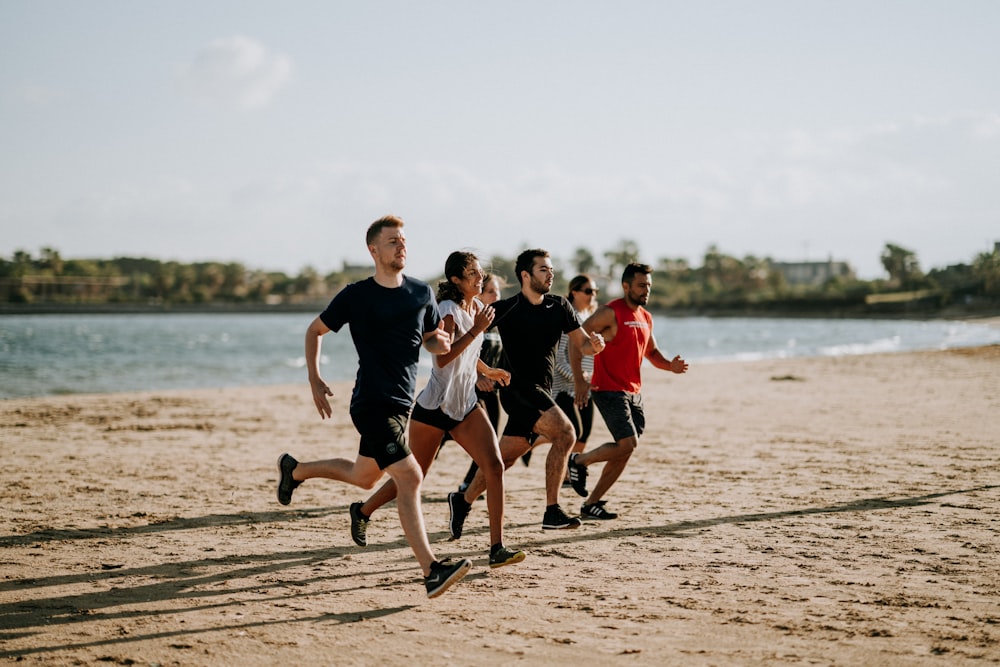 hombres y mujeres corriendo a la orilla del mar