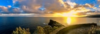 A panoramic view of Isla Isabel’s rocky coastline under a golden sunset.