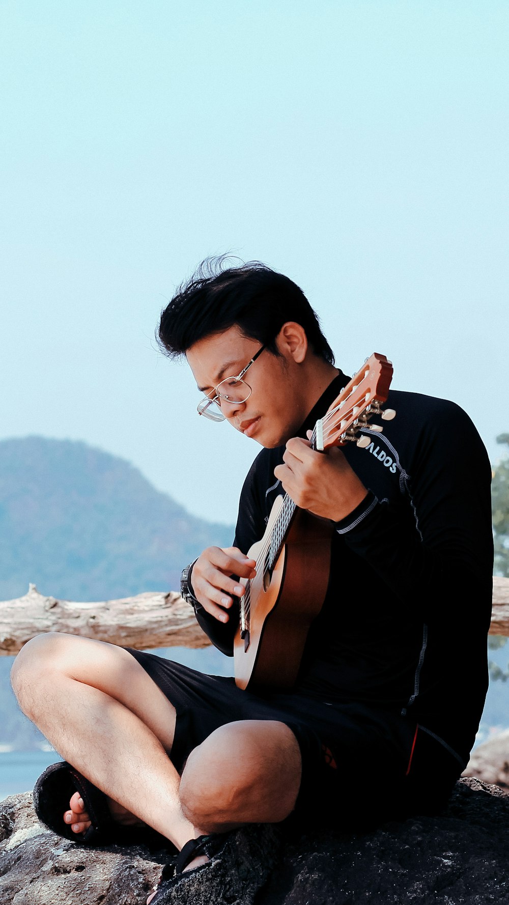 man sitting while playing ukulele