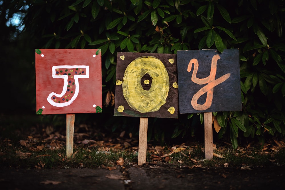 three assorted-color joy signage