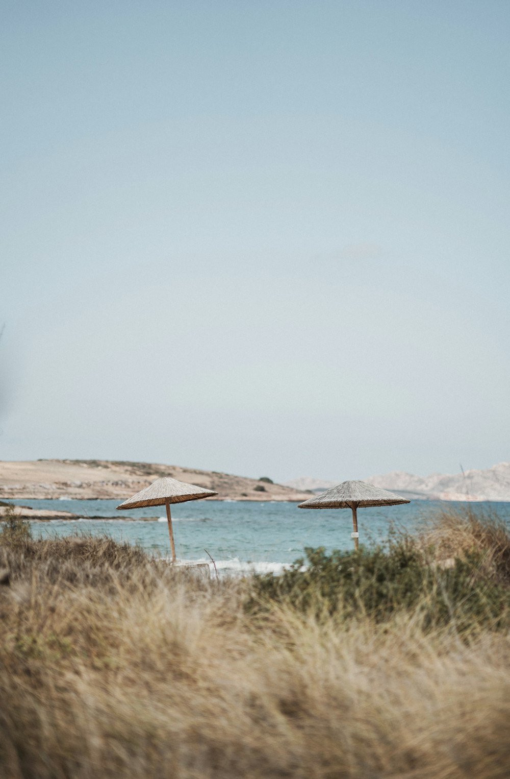 landscape photography of body of water and patio umbrella