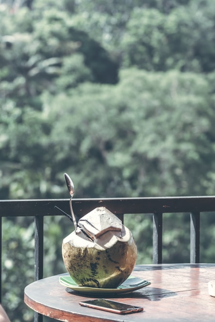 A refreshing bottle of coconut water with tropical leaves in the background