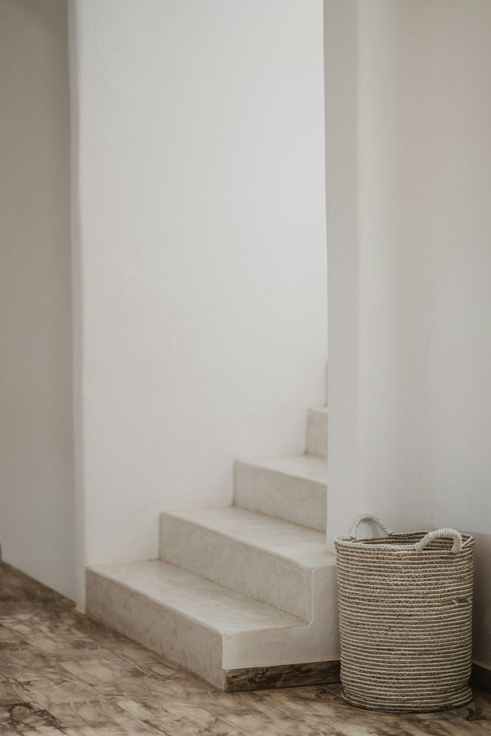 gray wicker basket beside stair