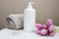 Flat lay of veloura wax warmer kit surrounded by soft rose pink towels and fresh flowers.