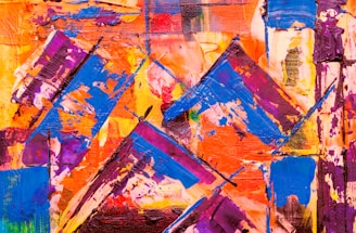 Bold and vibrant abstract painting with dynamic brush strokes and geometric shapes. The canvas is filled with intersecting patterns and overlapping colors creating a sense of motion and energy.