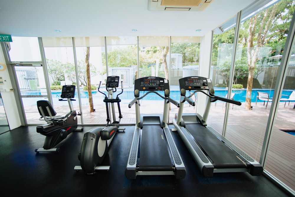 Tapis roulants noirs et vélos elliptiques dans la salle vitrée