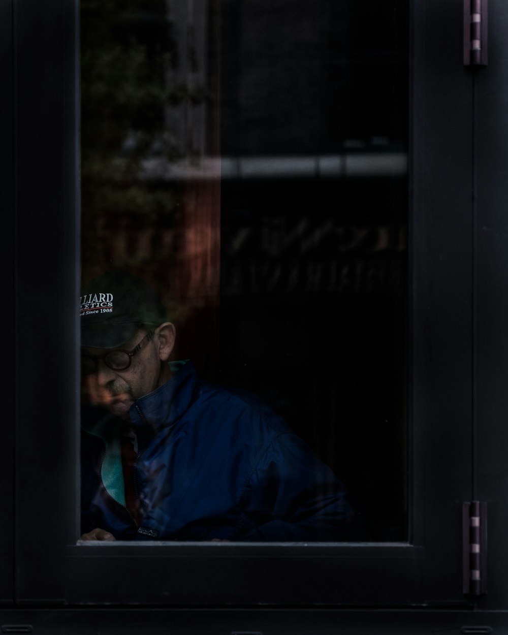 a man looking at his cell phone in a window