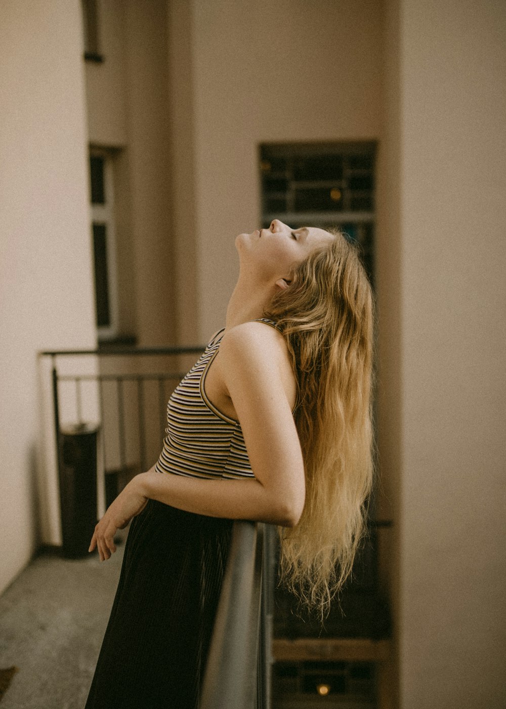 woman leaning backwards into metal railing