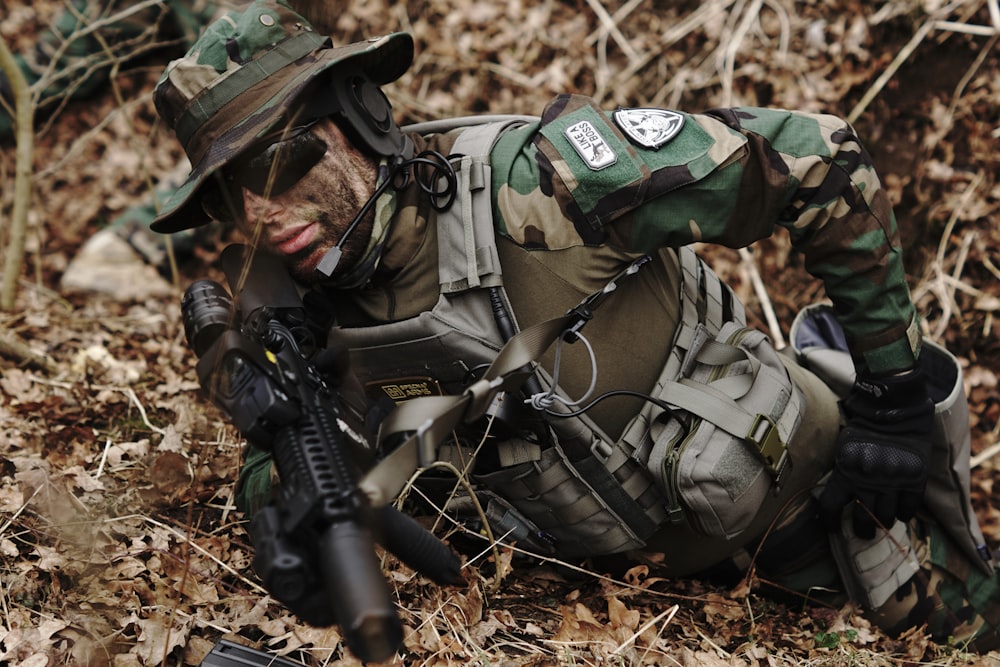 man holding rifle on ground