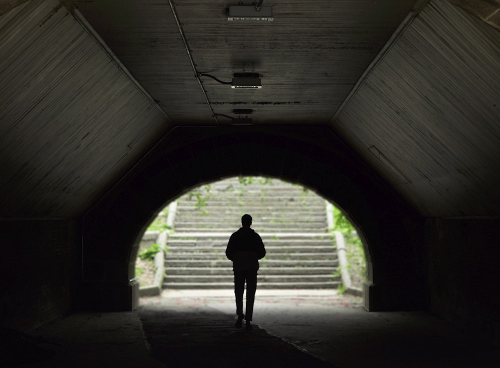 man standing inside tunnel