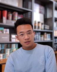 man wearing eyeglasses and blue shirt inside coffee shop