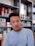 man wearing eyeglasses and blue shirt inside coffee shop