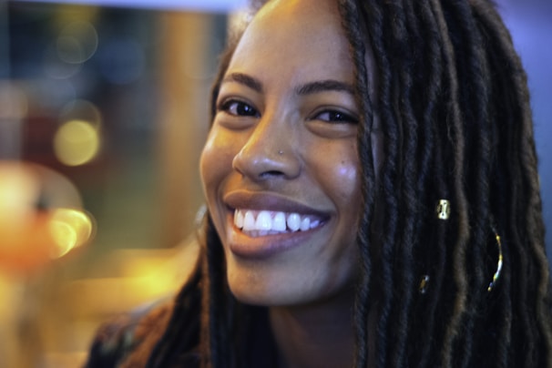 Boho knotless bob braids with soft curly ends framing a smiling face