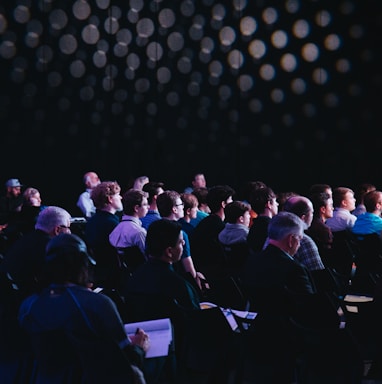 crowd of people sitting on chairs inside room