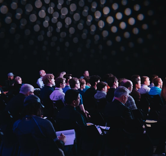 crowd of people sitting on chairs inside room