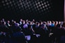crowd of people sitting on chairs inside room