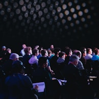 crowd of people sitting on chairs inside room