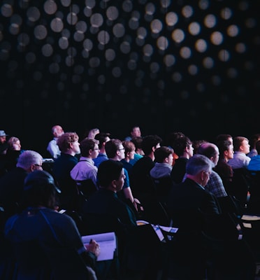 crowd of people sitting on chairs inside room