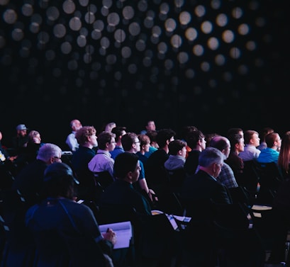 crowd of people sitting on chairs inside room